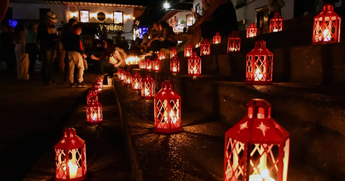 Faroles rojos encendidos en escalinatas de Salamina durante la Noche del Fuego, con personas reunidas en celebración nocturna.