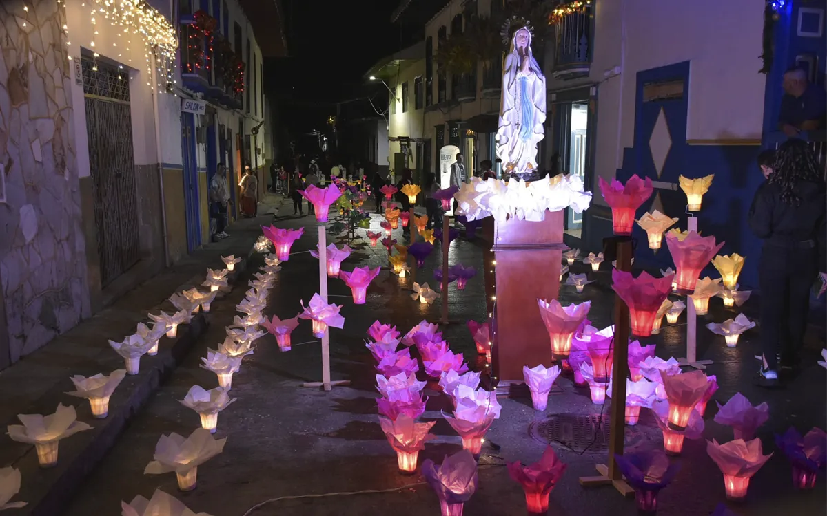 Faroles florales rodean la imagen de la Virgen María en calle iluminada de Salamina