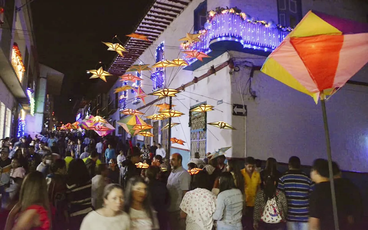 Calle decorada con faroles en forma de estrellas y cometas durante la Noche del Fuego